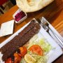 De Iraakse (Irakese?) keuken? Er zal niet bij iedereen een lampje gaan branden. Tant pis, een gemis. Ga bijvoorbeeld naar Star BBQ op de Javastraat: je bestelt een kebab (op een zwaard), je krijgt die kebab èn vers gebakken flat bread - ik kreeg er twee, een dikker (hoe kan dat bij flat bread) en een dunner, een met sesam en een zonder - knoflooksaus, ingelegde paarse groente, sla en een uienmix. Ik bestelde ook nog thee en zelfs die was top. Oh en dat alles voor €13. 
#hoedan #amsterdamoost #kebab #iraq #debuikvanamsterdam #foodtips #amsterdam